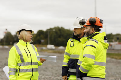 Engineers in reflective clothing looking at plans