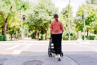 Rear view of man walking on footpath