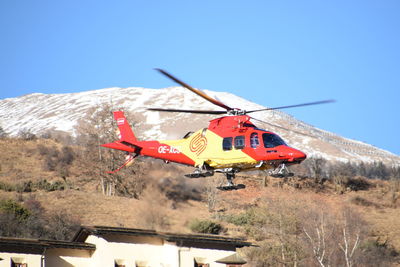 Airplane flying over mountains against clear sky