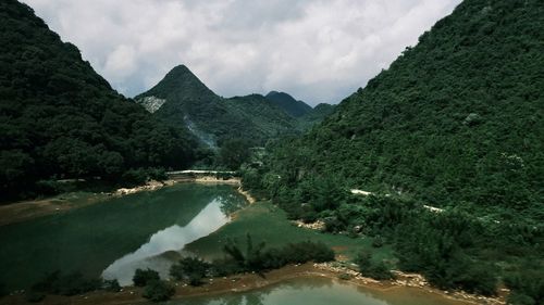 Scenic view of river amidst mountains against sky