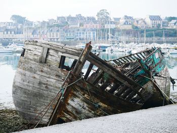 Abandoned boats moored on sea against sky