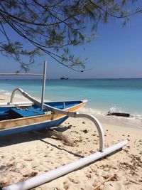 Boats moored on beach against clear sky