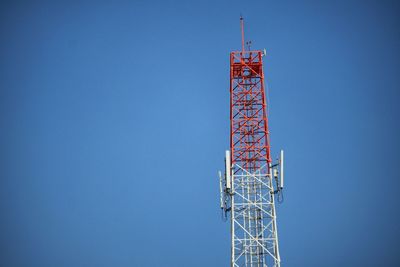 Low angle view of communications tower against clear blue sky