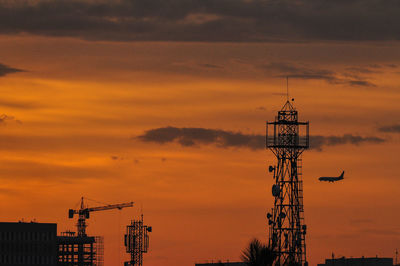 Low angle view of crane against cloudy sky