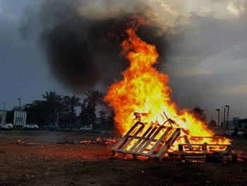 Wood set on fire against sky