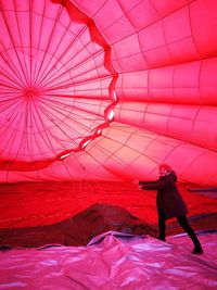 Full length rear view of man standing against colorful balloons