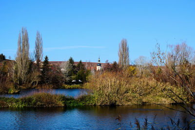 Scenic view of lake against clear blue sky