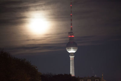 Low angle view of communications tower in city against sky