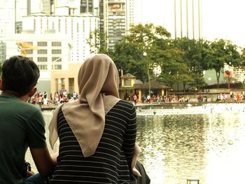 Rear view of people against buildings in city