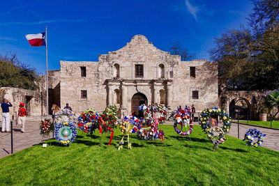 People in front of building against blue sky