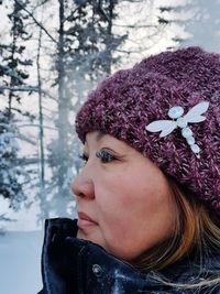 Portrait of woman wearing hat against trees during winter