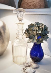 Close-up of white flower in glass vase on table at home