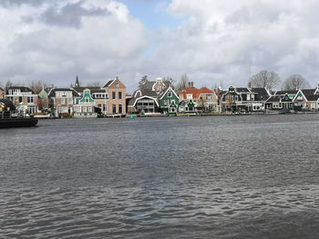 River by buildings against sky in city