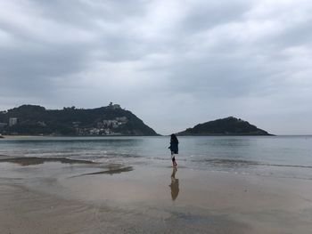 Man standing on beach against sky