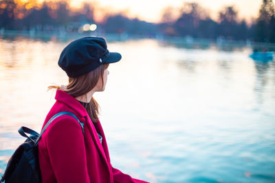 Side view of woman looking at lake during winter