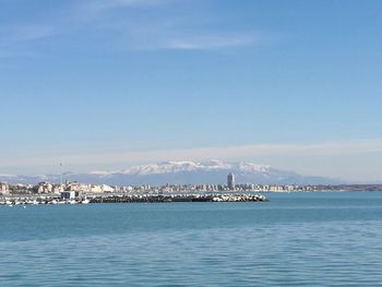 Scenic view of sea by city against sky