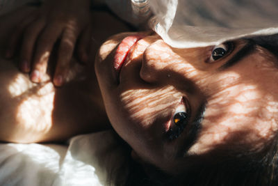 Close-up of young woman lying on bed