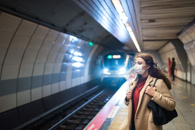 Full length of woman standing at subway station