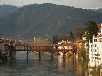 Bridge over river amidst buildings in city