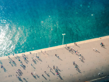 High angle view of people walking on promenade by sea