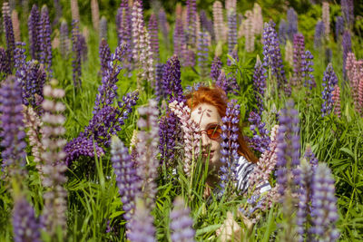 Beautiful young woman in the field of lupins