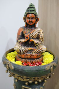 Close-up of buddha statue against wall