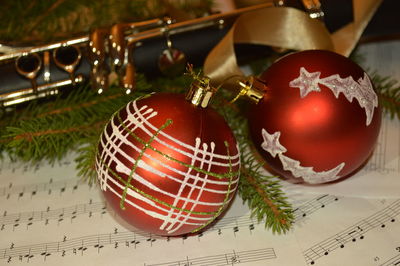 Close-up of christmas ornaments on musical notes