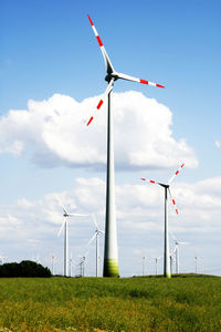 Low angle view of windmill on field against sky