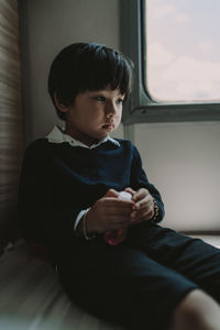 Boy sitting by window in train