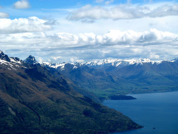 Scenic view of mountains and sea against cloudy sky