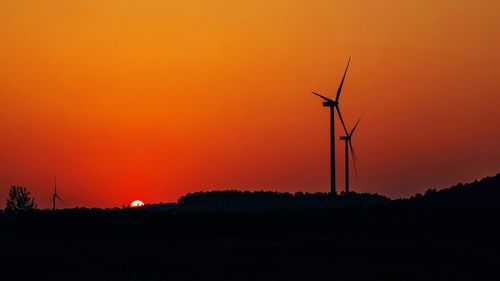 Silhouette of wind turbines at sunset