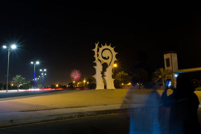 Light trails on street against sky at night