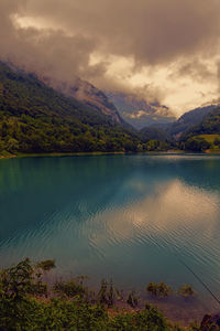 Scenic view of lake by mountains against sky