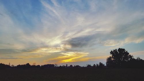 Silhouette field against sky during sunset