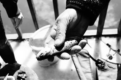 Fisherman holding dead fish in hand