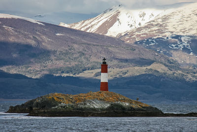 Lighthouse by sea against sky