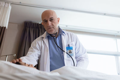 Portrait of doctor examining patient in hospital