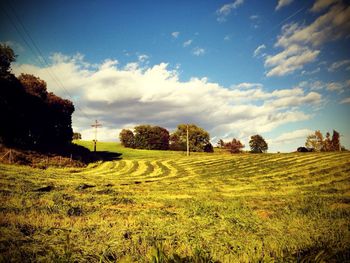 Scenic view of field against cloudy sky