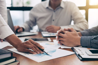 Midsection of business people during meeting in office