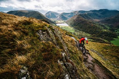 People riding on mountain against sky