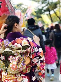 Rear view of woman in kimono on footpath