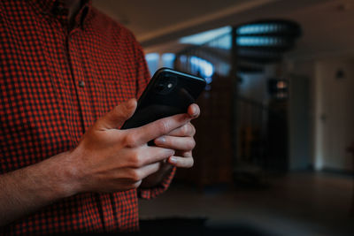 Midsection of man using mobile phone