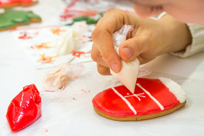 Close-up of hand holding ice cream on table