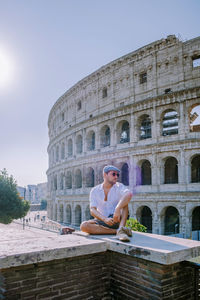 Woman looking at historical building against sky