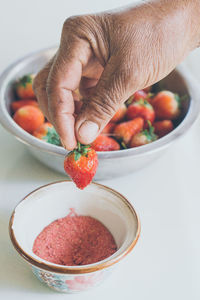 High angle view of hand holding fruits in bowl