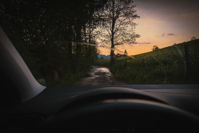 Road seen through car windshield during sunset