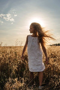 Woman standing on field against sky