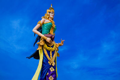 Low angle view of female statue against blue sky