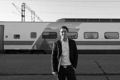 Full length portrait of young man standing on train