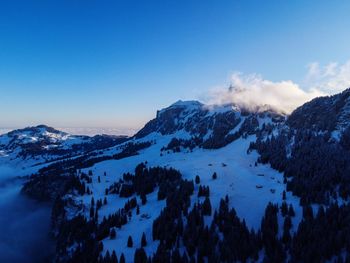 Scenic view of snow covered mountains against sky